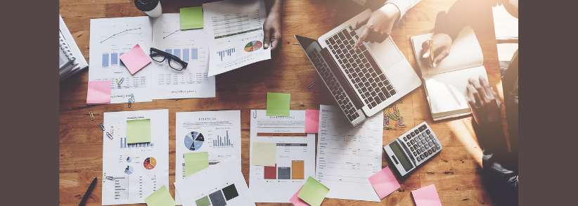 Hire skilled marketing talent People gathered around the table with papers with graphs realizing the need to hire skilled marketing talent