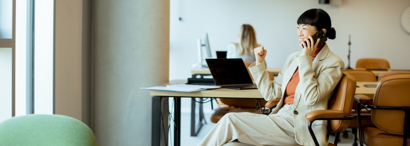 Modern publicist on phone at desk celebrating success